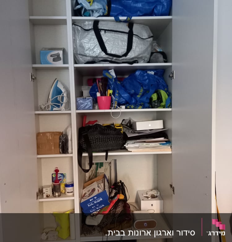 ארון עם תיקים, קופסאות, מגהץ ומוצרי ניקוי